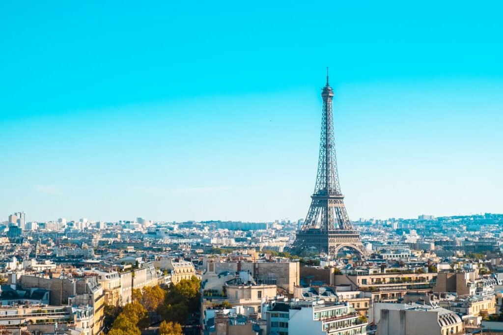 Eiffel Tower overlooking the cityscape of Paris under clear blue skies.