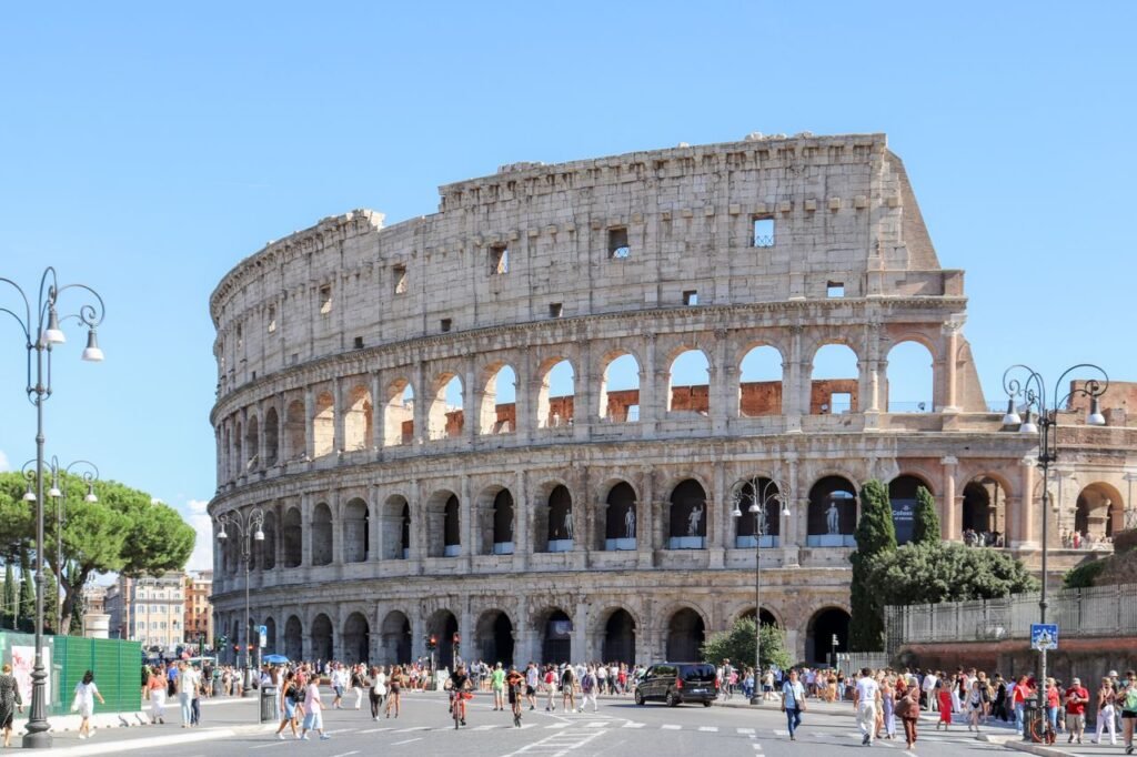 The Colosseum in Rome, Italy, bustling with tourists on a sunny day.